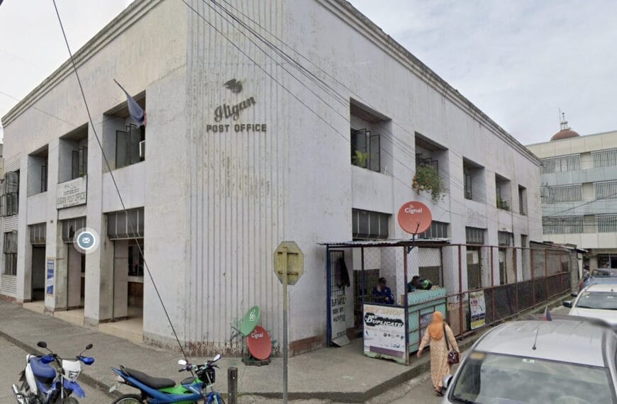 Baguio Post Office Building, Philippines, na may mga motorsiklo at kotse na nakaparada sa labas sa isang maulap na araw.